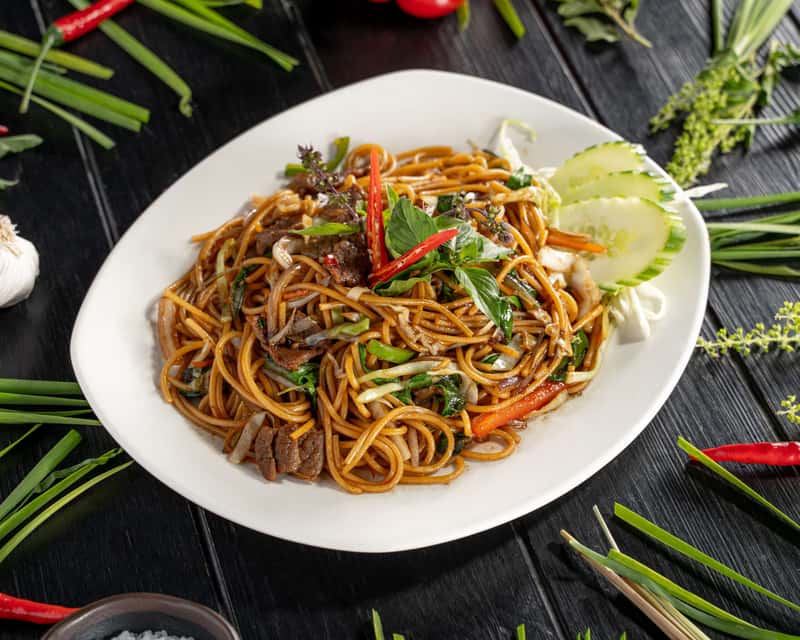 Stir-fried egg noodles with onion, spring onion, sweet pepper, holy basil in savory sauce.