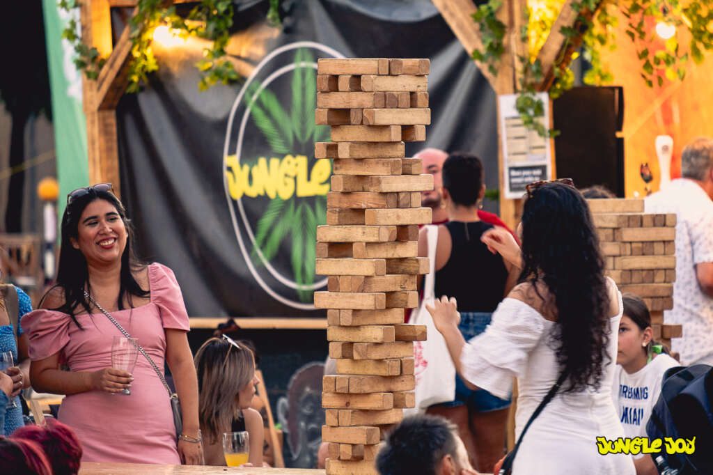 Two girls playing Giant Jenga in the Jungle Joy bar stand at the Pinta Beer Festival.